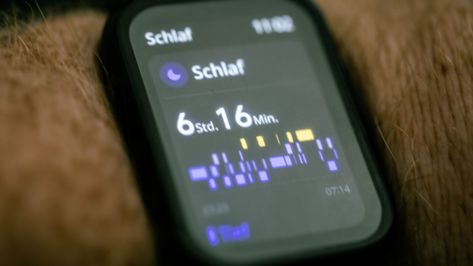 Close-up of a smartwatch display showing sleep tracking data with stages visualized in colored blocks