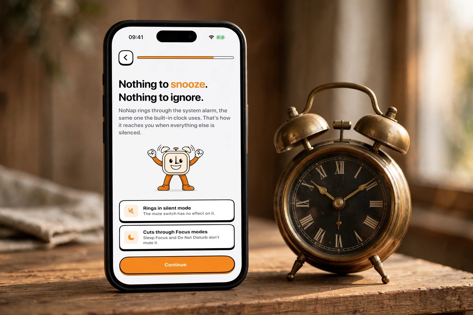 An iPhone beside an antique brass twin-bell alarm clock, showing NoNap's screen explaining that alarms ring through silent mode and Focus